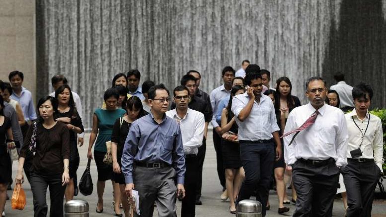Office workers walk through the central business district during lunch break.PHOTO: BLOOMBERG
